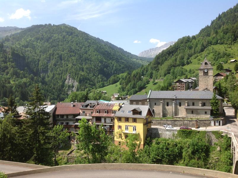 Le village de Flumet - Vue du village de Flumet, son église, ses maisons suspendues depuis la route de la Germandière. Massifs verdoyants en fond. Le village de Flumet - Vue du village de Flumet, son église, ses maisons suspendues depuis la route de la Germandière. Massifs verdoyants en fond.
